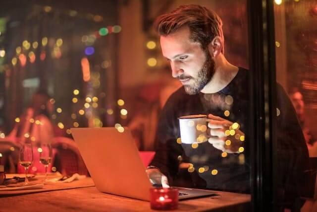 A man holding a cup of coffee, representing German Daily Routine Vocabulary Quiz.