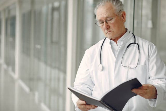 A senior doctor reading clinical records, symbolising professionalism in healthcare, related to A German Short Story featuring at the Doctor Vocabulary.