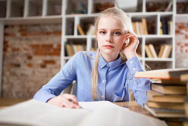 A student in a library studying German separable verbs and focusing on mastering complex grammar rules.