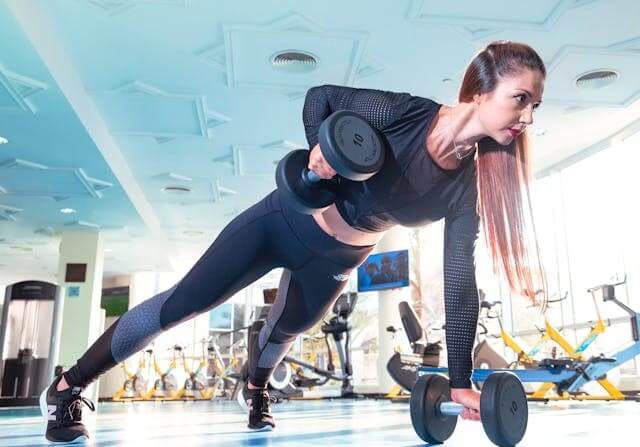 A woman working out in a gym, symbolizing fitness and activity in the German Sports Vocabulary Quiz.