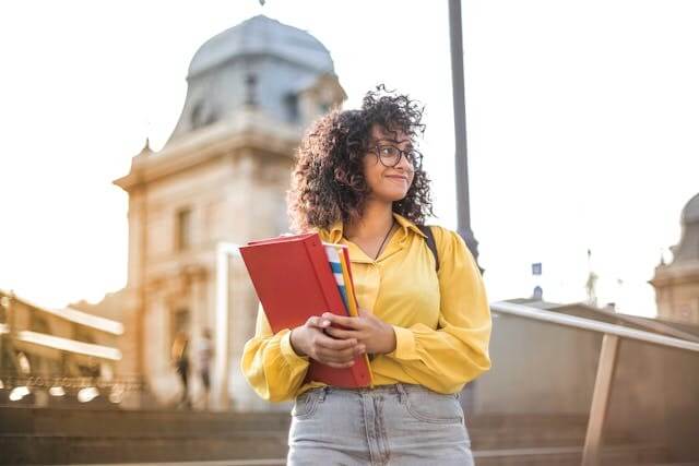 Confident student holding books to symbolize preparation for a German prepositions quiz.