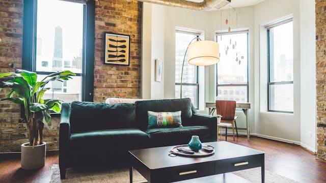 Cozy apartment with a brick wall and green sofa, representing German home and living vocabulary.