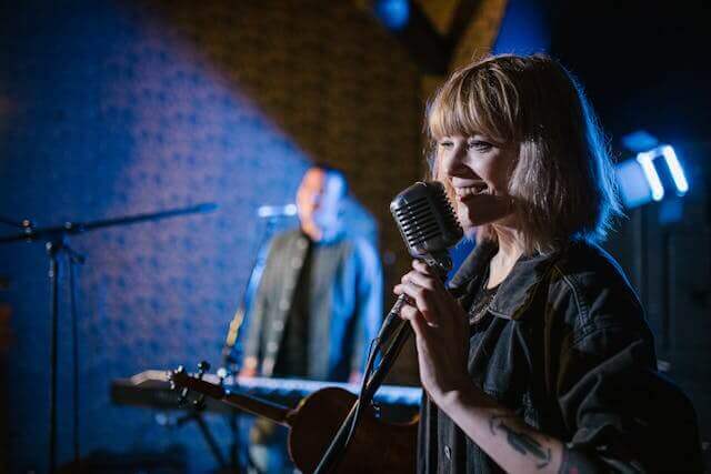 Female singer performing on stage, representing terms from German hobbies vocabulary related to music and performing arts.