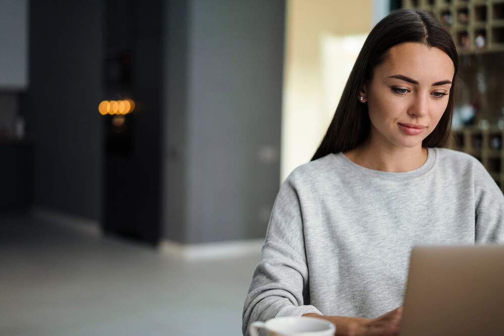 Focused woman using a laptop to show engagement with a German articles quiz