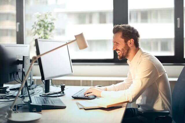 Professional man working at a desk with a computer, showcasing German office vocabulary.