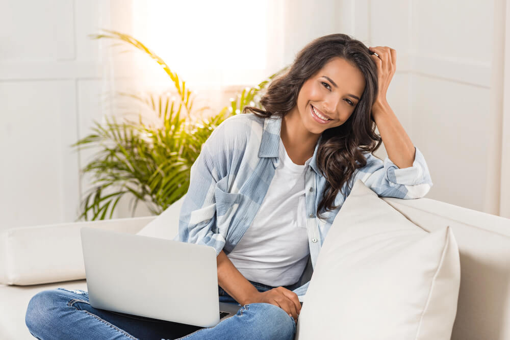 Relaxed woman with a laptop studying German Causal Clauses at home.