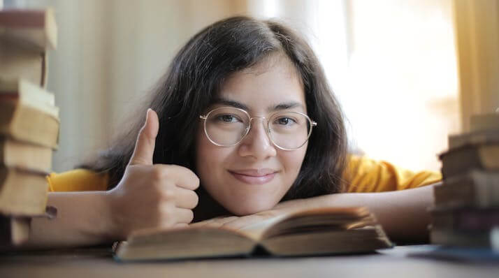 Smiling student giving a thumbs-up to show confidence in completing our German A1 grammar quiz.