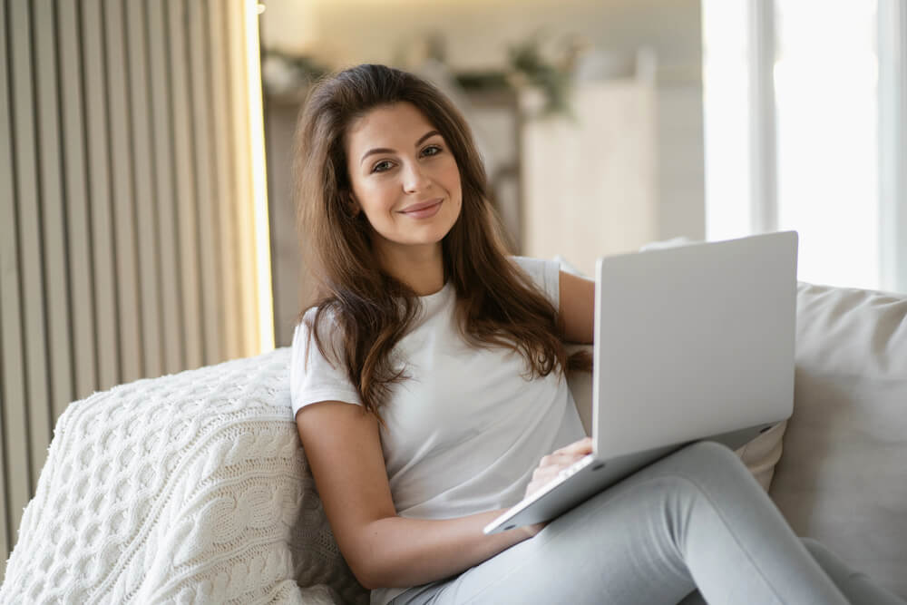 Smiling woman using a laptop to show engagement with a German relative clauses grammar quiz