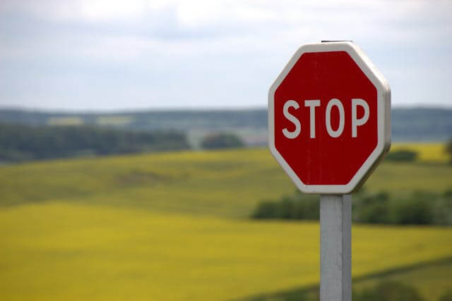 Stop sign in a scenic field, illustrating the use of the German imperative