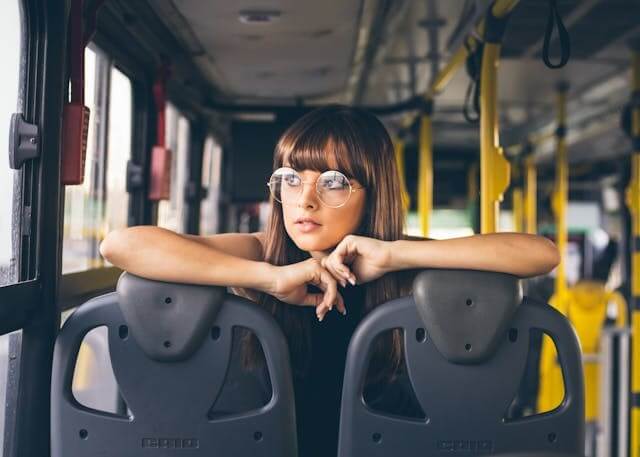 Woman sitting on a bus, symbolizing travel and practice with a German travel and direction video quiz