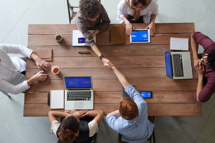 Group of professionals in a business meeting discussing projects, ideal for learning German business vocabulary terms like 'Verhandlung' and 'Unternehmen'.