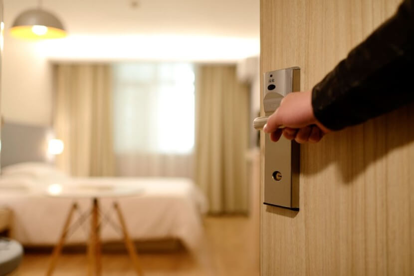 A guest opening the door to a hotel room, ideal for learning German vocabulary for hotels and accommodation.