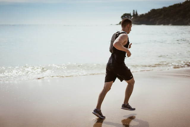 Man running on the seashore to symbolize aspirations in a German short story featuring vocabulary for plans and wishes.