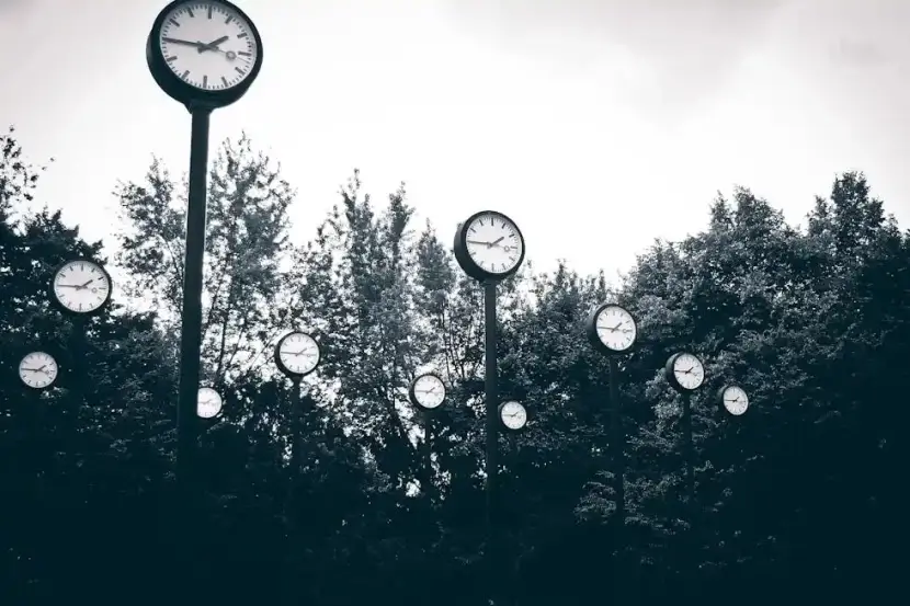 Outdoor clocks in a forest, representing German temporal prepositions like 'um' (at) and 'vor' (before).