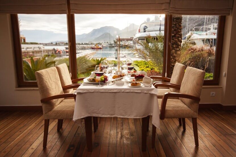 Scenic restaurant table setting with a waterfront view, showcasing German vocabulary for cafés and restaurants.