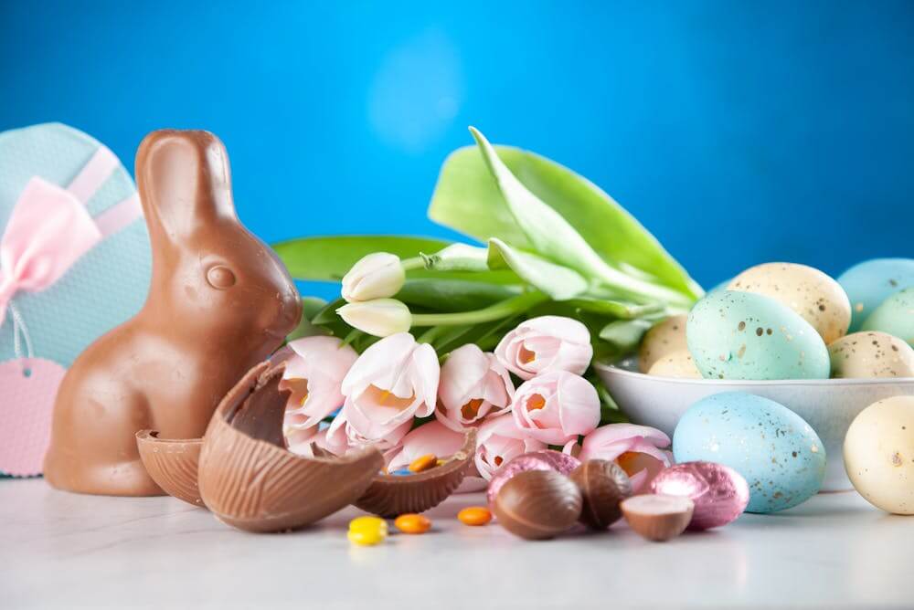 Chocolate Easter bunny with colorful eggs – German holiday & celebration vocabulary.