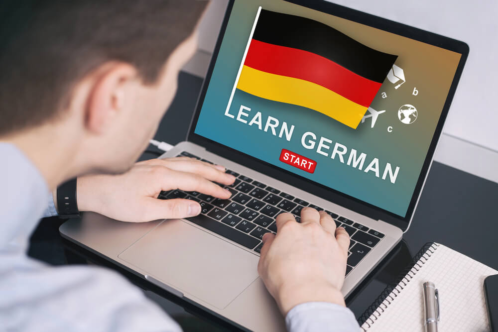 Man learning German online with a private tutor on a laptop, showcasing the convenience of German online lessons with a tutor.