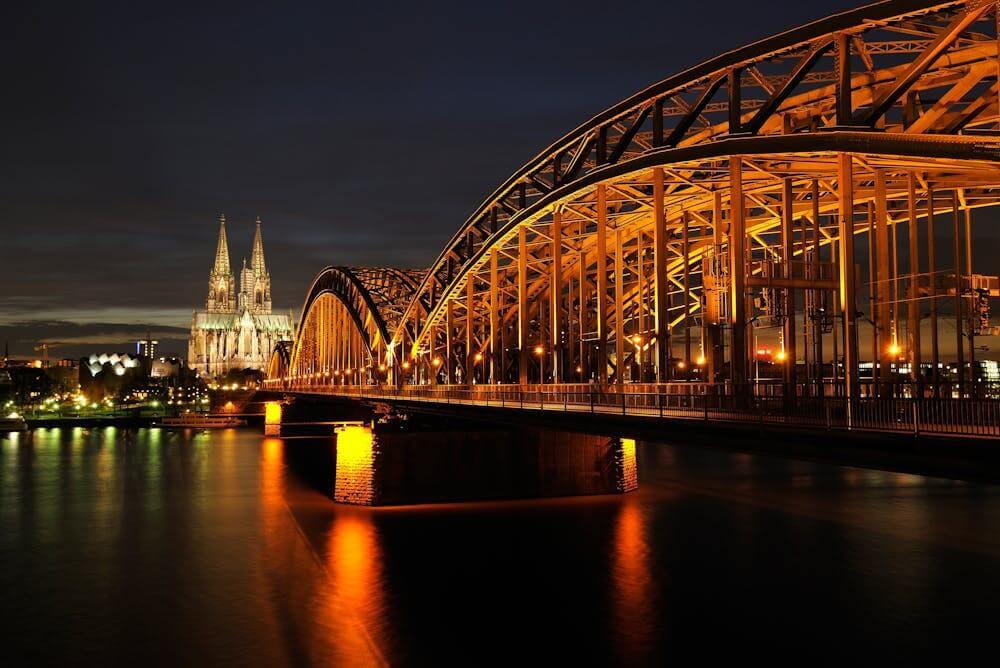 Night view of Cologne Cathedral and Hohenzollern Bridge, symbolic of German grammar learning.