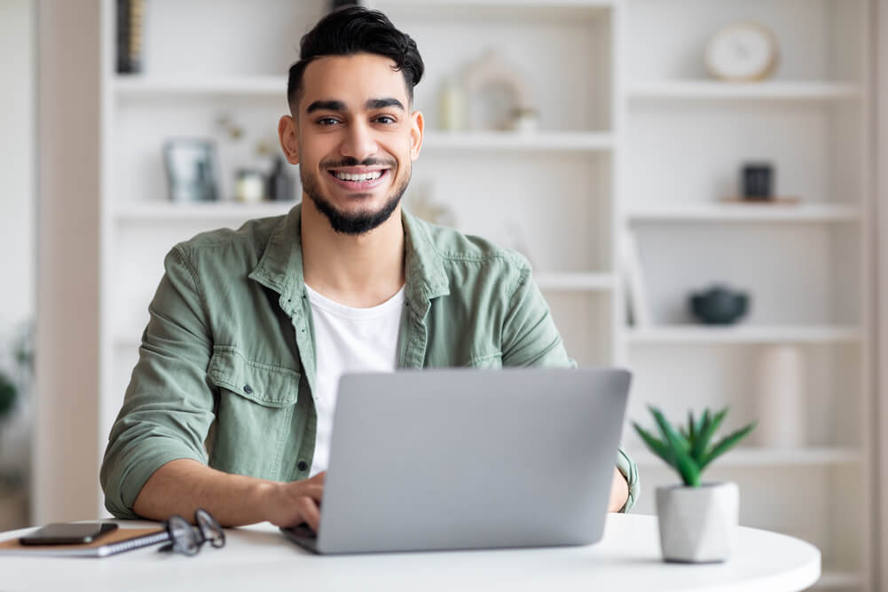 Smiling man learning German adjective declension with definite articles.