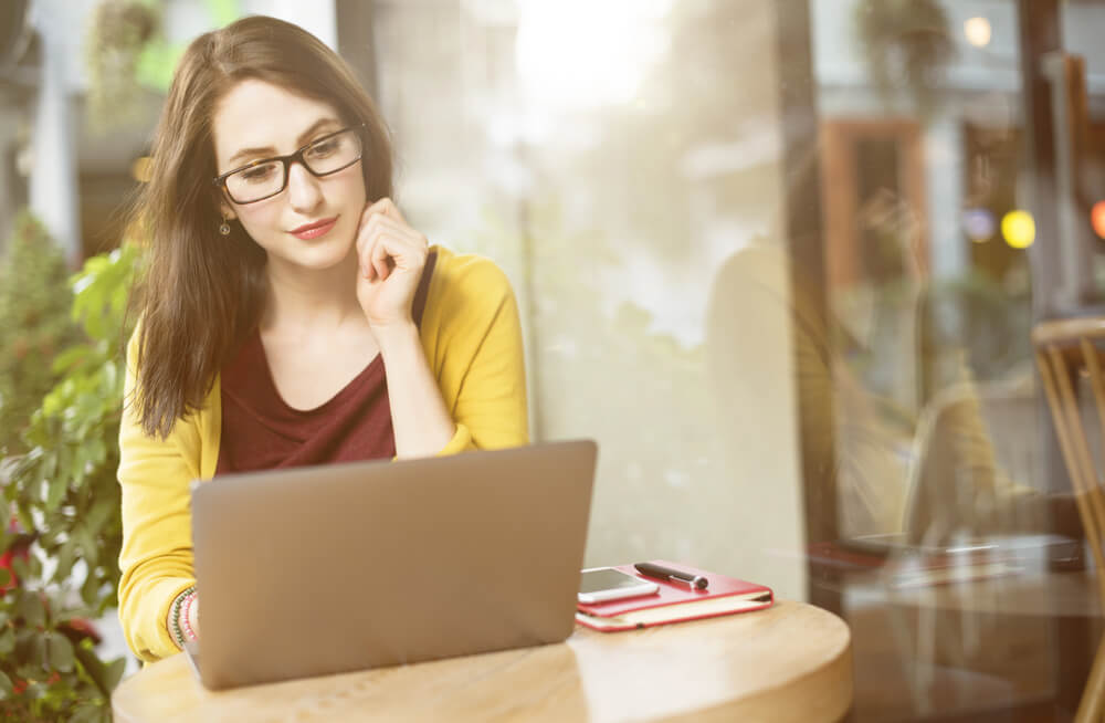 Woman practicing German verb werden conjugation on her laptop.