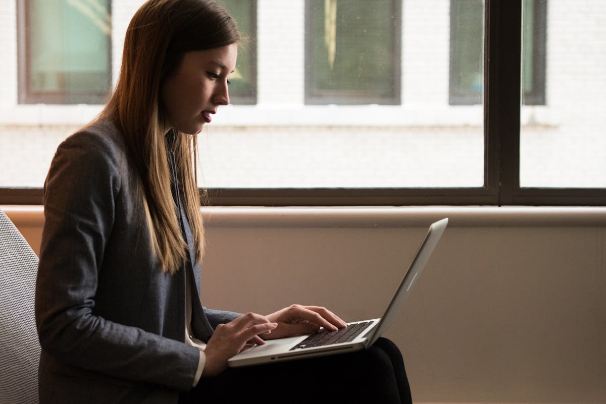 Woman studying the difference between kennen and wissen in German grammar on a laptop